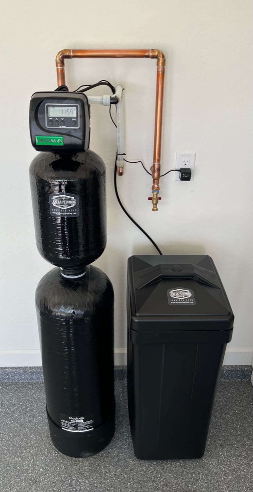 Water filtration system with a digital monitor and storage tank in a residential setting.