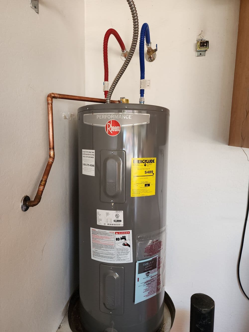 Rheem Performance water heater with copper pipes and installation details.