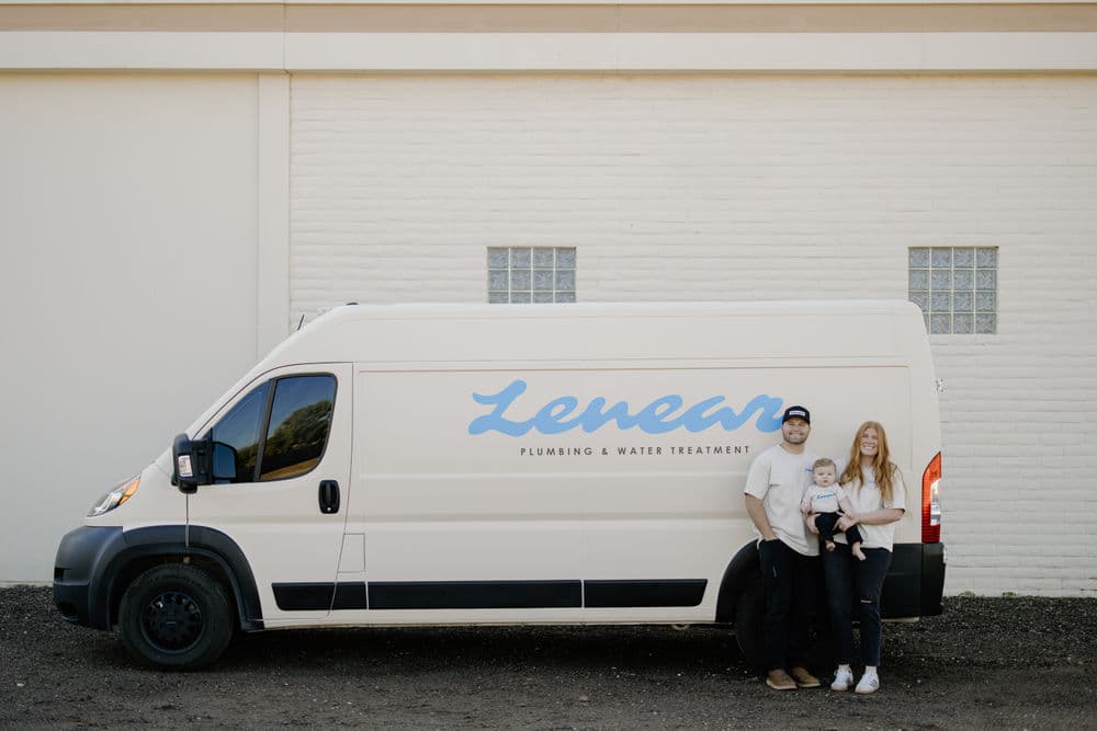Family standing beside a Lenear Plumbing & Water Treatment van, promoting family-owned service.